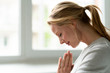 © Westend61 - Smiling young woman with closed eyes and clasped hands