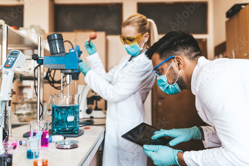 Fotomural Two middle age scientists and researchers work in chemical laboratory