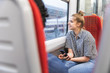 © Westend61 - Smiling young man travelling by train with her boyfriend on rainy day looking out of window, London, UK