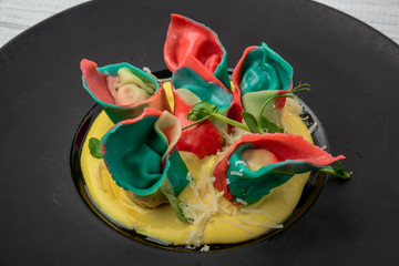 Wall Mural - Red ravioli with mushrooms served on a black plate