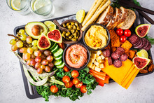 Meat And Cheese Appetizer Platter. Sausage, Cheese, Hummus, Vegetables, Fruits And Bread On Black Tray.