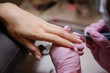 © КРИСТИНА Игумнова - Woman in salon receiving manicure by nail beautician,manicurist uses a manicure nail file to process the nail plate and nail file