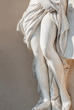 Fototapeta Desenie - Statue of ancient sensual half naked Renaissance Era woman with long baked legs in Potsdam at smooth wall background, Germany