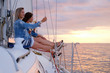 © Fxquadro - Two joyful women are celebraiting good summer day at the yacht while watching beautiful sunset.