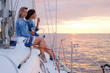 © Fxquadro - Two joyful women are celebraiting good summer day at the yacht while watching beautiful sunset.