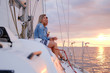 © Fxquadro - Two joyful women are celebraiting good summer day at the yacht while watching beautiful sunset.