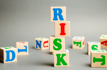Wall Mural - wooden blocks with the word risk and randomly scattered cubes. management, cost assessment, business