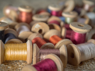 Wall Mural - Bright thread on wooden spools, thimbles and needles