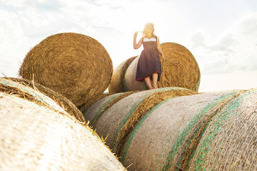 Wall Mural - Frau in Tracht vor einem Strohballen an einem sonnigem Tag in bayern