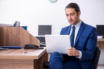 Young handsome businessman working in the office