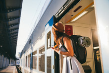 Woman Peeking Out Train. Woman Railway Station. Young Happy Woman Pulling Face Out Train Door Looking For Somebody Railway Station. Travelling. Portrait Girl Standing On Train Door When Arrived
