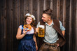 © karepa - Junge Frau und mann mit Bierkrug und Brezel auf einem Holzhintergrund .Oktoberfest-Konzept