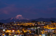 Cityscape of Quito at night with the impressive Cayambe volcano, Andes mountains, Ecuador, South America.