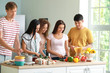 © Pixel-Shot - Happy friends cooking together in kitchen