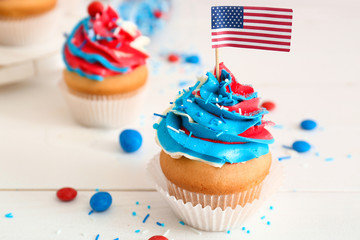 Tasty patriotic cupcakes on table