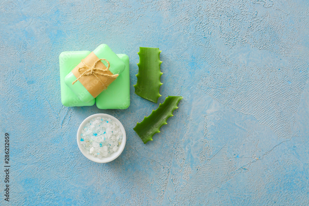 Soap with aloe vera extract and sea salt on color background