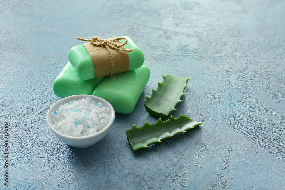 Soap with aloe vera extract and sea salt on color background