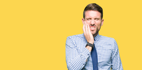 Wall Mural - Handsome business man wearing tie touching mouth with hand with painful expression because of toothache or dental illness on teeth. Dentist concept.