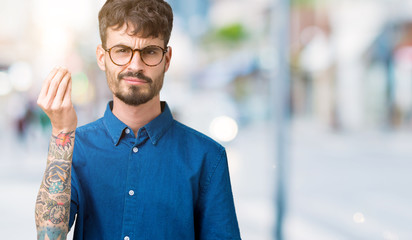 Sticker - Young handsome man wearing glasses over isolated background Doing Italian gesture with hand and fingers confident expression