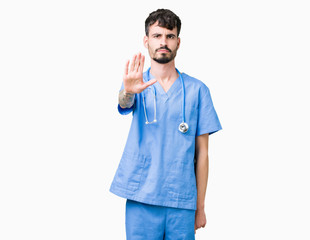 Poster - Young handsome nurse man wearing surgeon uniform over isolated background doing stop sing with palm of the hand. Warning expression with negative and serious gesture on the face.