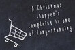 Chalk drawing of shopping cart and short quote about shopping on black board