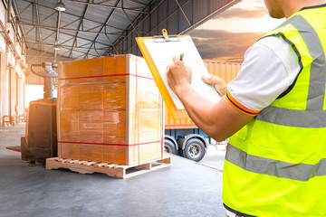 Worker Courier Holds a Clipboard Controlling the Loading of Packaging Boxes into Shipping containers. Supply Chain. Forklift Tractor Trucks Loading at Dock Warehouse. Cargo Shipment.	