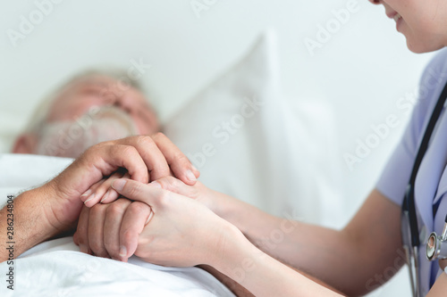 Senior man in bed with nurse in retirement home Tableau sur Toile
