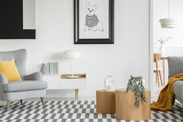 Black and white poster of dog on the wall of fashionable living room interior with two wooden coffee tables with flowers