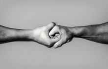 Two Hands, Isolated Arm, Helping Hand Of A Friend. Rescue, Helping Hand. Male Hand United In Handshake. Man Help Hands, Guardianship, Protection. Black And White