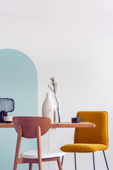 White vase on wooden table with fancy dining room interior with white and blue wall