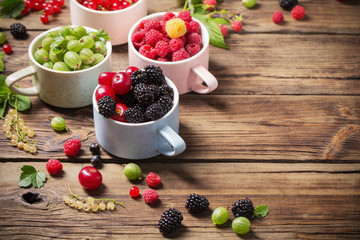 Wall Mural - different berries on old wooden background