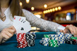 © RomanR - Female hands with playing cards and poker chips