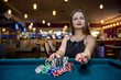 © RomanR - Woman in casino takes chips from pile