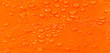 Raindrops on a tent of orange color as an abstract background