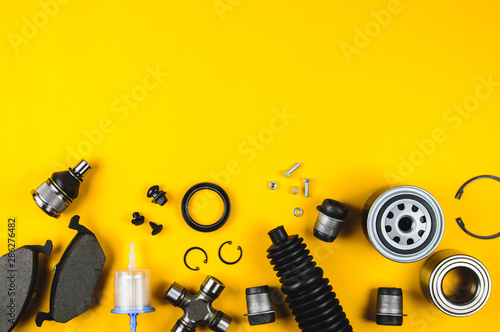 Fotografía Set of car parts for maintenance on yellow background