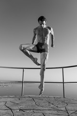 Young beautiful male ballett dancer posing by the sea