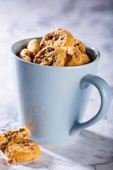 Wall Mural - Chocolate chip cookies in blue cup on marble stone background. Selective focus. Copy space.