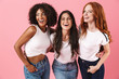 © Drobot Dean - Happy young three multiethnic girls friends posing isolated over pink wall background.