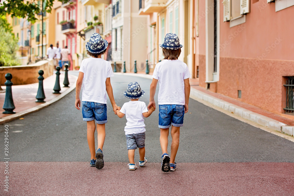 Obraz na płótnie Children walking on a narrow street with houses in Monaco-Ville, Monaco on a cloudy day w salonie