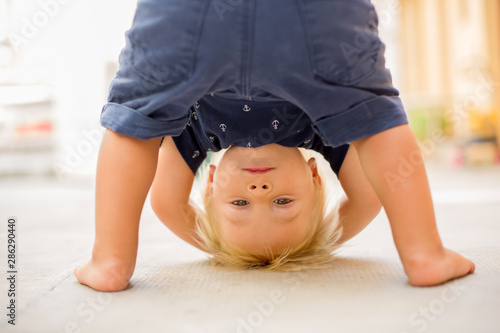 Fotografía Child standing upside down, smiling happily