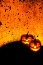 Halloween Background Wallpaper With Jack O Lantern Scary Pumpkins On Grunge Textured Orange Backdrop.