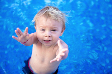 Sticker - Adorable happy little child, toddler boy, having fun relaxing and playing in a pool on sunny day during summer vacation