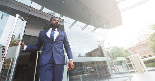 Fotomural Young african job seeker leaving building after interview