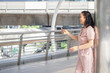 © PANYA - Healthy middle-aged women look happy wearing pink pants outdoor ambience with modern communication tools, smartphone