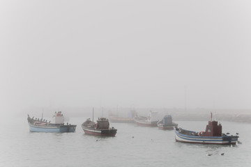 Fishing boats anchored in the fog