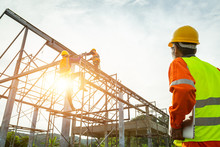 A Construction Worker Control In The Construction Of Roof Structures On Construction Site And Sunset Background