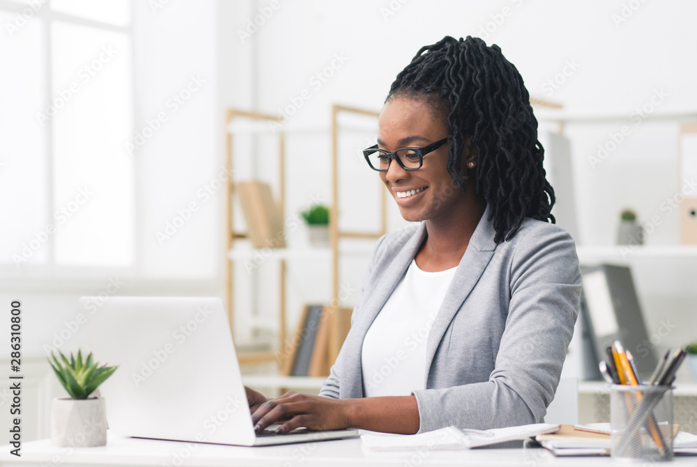 Black Female Entrepreneur Using Laptop In Modern Office - obrazy, fototapety, plakaty 