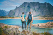 © olezzo - Two girls stand holding hands on the background of the Lofoten Islands, traveling to Norway, Scandinavia northern Europe