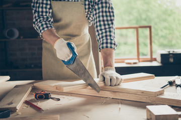 Cropped close-up view of his he nice skilled guy expert using instrument cutter creating new furniture order house home box frame at industrial brick loft style interior workplace indoors