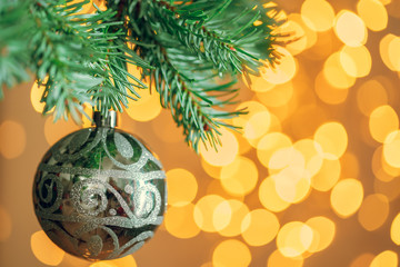 Christmas tree background with golden bauble on bokeh sparkling